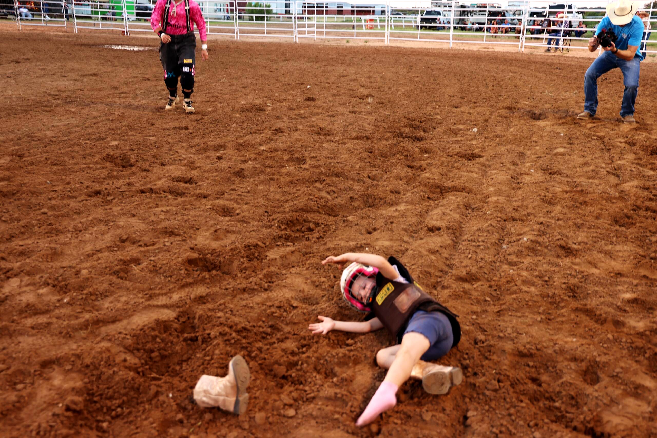 Young rider down in the dirt arena after a ride